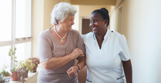 Personal Support Worker helping a elderly person walk