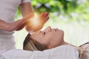 Woman having reiki healing treatment , alternative medicine concept.