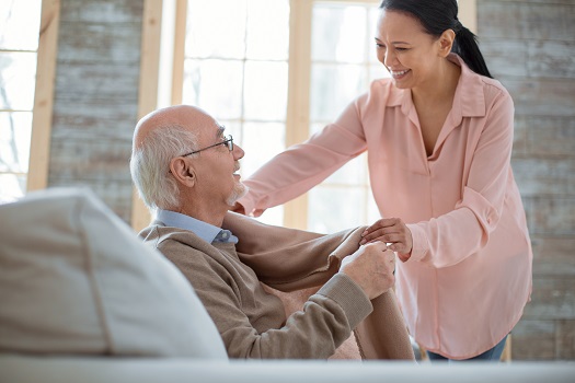 attentive and kind Personal Support Worker PSW covering a senior with a blanket